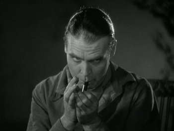 Movie still from “Ladies of Leisure” (1930), directed by Frank Capra – A black and white photo of a man smoking a cigarette; Close Up shot, Low angle