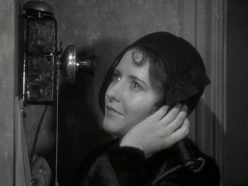 Movie still from “Ladies of Leisure” (1930), directed by Frank Capra – A black and white photo of a woman with a hair dryer; Close Up shot, High angle
