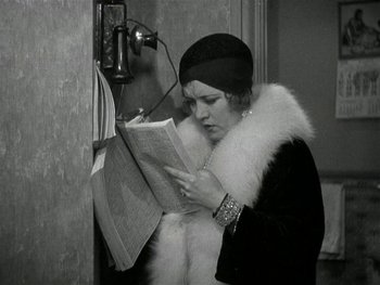 Movie still from “Ladies of Leisure” (1930), directed by Frank Capra – An old photo of a woman reading a newspaper; Medium shot, High angle