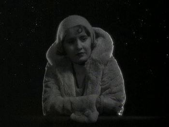 Movie still from “Ladies of Leisure” (1930), directed by Frank Capra – An old photo of a woman wearing a fur coat; Medium shot, High angle