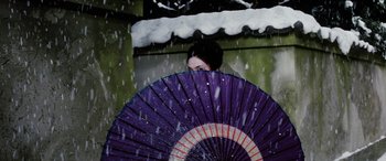 Movie still from “Lady Snowblood” (1973), directed by Toshiya Fujita – A woman holding an umbrella in the snow; Medium shot, High angle