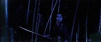 Movie still from “Lady Snowblood” (1973), directed by Toshiya Fujita – A woman holding a sword standing in the woods; Medium shot, Low angle