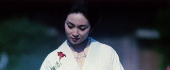Movie still from “Lady Snowblood” (1973), directed by Toshiya Fujita – A woman in a white robe holding a red flower; Close Up shot, Over the shoulder angle