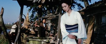 Movie still from “Lady Snowblood” (1973), directed by Toshiya Fujita – A woman in a white dress standing next to a tree; Medium shot, Low angle