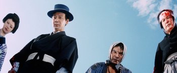 Movie still from “Lady Snowblood” (1973), directed by Toshiya Fujita – A man in a blue hat and a man in a black hat; Medium shot, Low angle