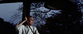 Movie still from “Lady Snowblood” (1973), directed by Toshiya Fujita – A man in white shirt holding onto a rope; Medium shot, Low angle
