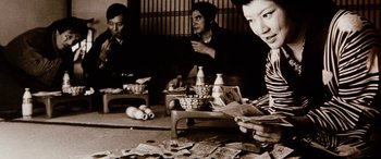 Movie still from “Lady Snowblood” (1973), directed by Toshiya Fujita – A group of people sitting around a table; Medium shot, Low angle
