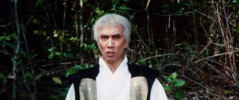 Movie still from “Lady Snowblood” (1973), directed by Toshiya Fujita – An older man in a white shirt and a black vest; Close Up shot, Low angle