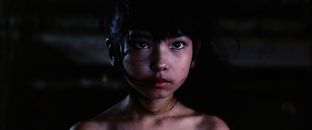 Movie still from “Lady Snowblood” (1973), directed by Toshiya Fujita – A young girl with blue eyes stares straight ahead; Close Up shot, Low angle