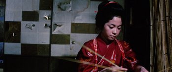Movie still from “Lady Snowblood” (1973), directed by Toshiya Fujita – A woman in a red kimono is playing a musical instrument; Close Up shot, Low angle