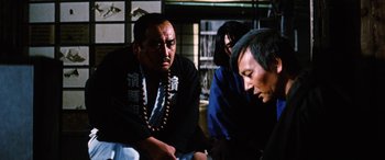 Movie still from “Lady Snowblood” (1973), directed by Toshiya Fujita – A group of people sitting in a room together; Medium shot, Over the shoulder angle