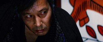 Movie still from “Lady Snowblood” (1973), directed by Toshiya Fujita – A person wearing a suit and tie; Close Up shot, Low angle