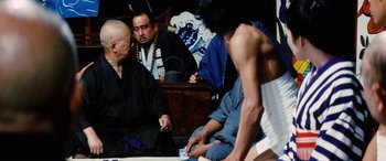 Movie still from “Lady Snowblood” (1973), directed by Toshiya Fujita – A group of men sitting around a table; Medium shot, Over the shoulder angle