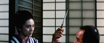 Movie still from “Lady Snowblood” (1973), directed by Toshiya Fujita – A person holding a knife in their hand; Close Up shot, Over the shoulder angle