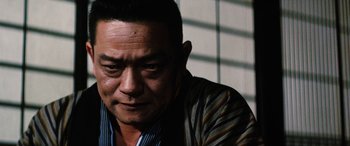 Movie still from “Lady Snowblood” (1973), directed by Toshiya Fujita – A person wearing a striped shirt; Close Up shot, Low angle