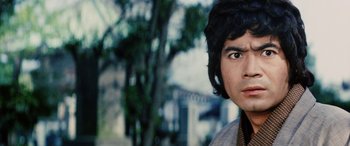 Movie still from “Lady Snowblood” (1973), directed by Toshiya Fujita – A young man with brown hair is looking at the camera; Close Up shot, Low angle