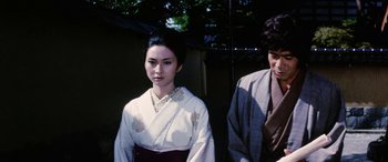 Movie still from “Lady Snowblood” (1973), directed by Toshiya Fujita – A woman in a kimono standing next to a man in a suit; Medium shot, Low angle