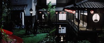 Movie still from “Lady Snowblood” (1973), directed by Toshiya Fujita – A man standing next to a lush green lawn; Extreme Wide shot, High angle