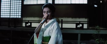 Movie still from “Lady Snowblood” (1973), directed by Toshiya Fujita – A woman in a kimono is singing into a microphone; Medium shot, Low angle