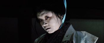 Movie still from “Lady Snowblood” (1973), directed by Toshiya Fujita – A woman in a black and white outfit with a blue headband; Close Up shot, Low angle