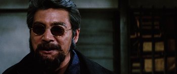 Movie still from “Lady Snowblood” (1973), directed by Toshiya Fujita – A person wearing sunglasses and a jacket; Close Up shot, Over the shoulder angle