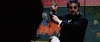 Movie still from “Lady Snowblood” (1973), directed by Toshiya Fujita – A man in a tuxedo holding a knife in his hand; Close Up shot, Low angle