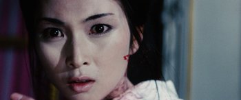 Movie still from “Lady Snowblood” (1973), directed by Toshiya Fujita – A woman's face with blood dripping from her mouth; Close Up shot, Over the shoulder angle