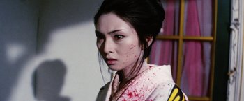 Movie still from “Lady Snowblood” (1973), directed by Toshiya Fujita – A woman with blood all over her face and neck; Close Up shot, Over the shoulder angle