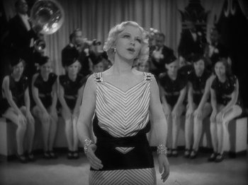 Movie still from “Lady for a Day” (1933), directed by Frank Capra – An old photo of a woman singing in front of a crowd; Medium shot, Low angle