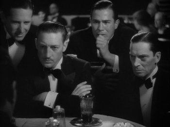 Movie still from “Lady for a Day” (1933), directed by Frank Capra – A black and white photo of a group of men sitting at a table; Medium shot, High angle