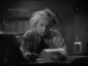 Movie still from “Lady for a Day” (1933), directed by Frank Capra – A man sitting at a table reading a paper; Medium shot, High angle