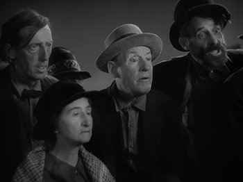 Movie still from “Lady for a Day” (1933), directed by Frank Capra – A black and white photo of a group of people wearing hats; Medium shot, Low angle