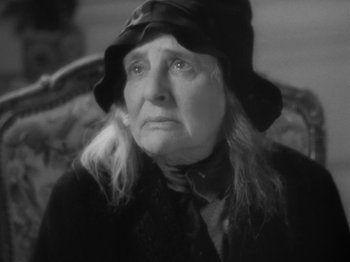 Movie still from “Lady for a Day” (1933), directed by Frank Capra – An older woman wearing a hat and looking sad; Close Up shot, High angle
