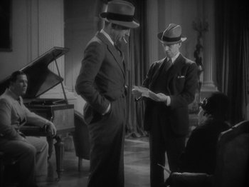 Movie still from “Lady for a Day” (1933), directed by Frank Capra – Two men in suits and hats looking at papers in a room; Medium shot, High angle