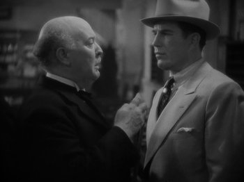 Movie still from “Lady for a Day” (1933), directed by Frank Capra – A man in a suit and a man in a hat; Close Up shot, Over the shoulder angle