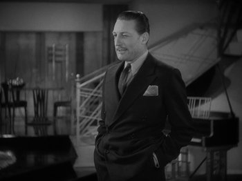 Movie still from “Lady for a Day” (1933), directed by Frank Capra – A black and white photo of a man in a suit and tie; Medium shot, Low angle