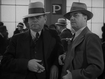Movie still from “Lady for a Day” (1933), directed by Frank Capra – A couple of men standing next to each other wearing hats; Medium shot, Low angle