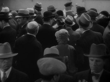 Movie still from “Lady for a Day” (1933), directed by Frank Capra – Black and white photograph of a crowd of people wearing hats; Medium shot, High angle