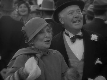 Movie still from “Lady for a Day” (1933), directed by Frank Capra – An older man and a woman are standing together in a crowd; Close Up shot, Low angle