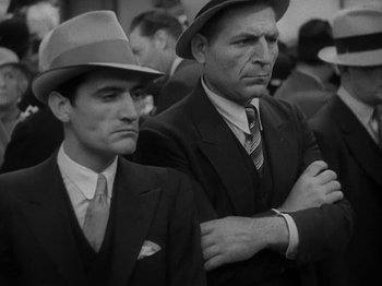 Movie still from “Lady for a Day” (1933), directed by Frank Capra – A couple of men standing next to each other in a crowd; Medium shot, Low angle