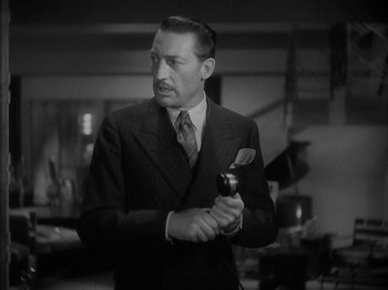 Movie still from “Lady for a Day” (1933), directed by Frank Capra – A man in a suit and tie holding a microphone; Close Up shot, Low angle