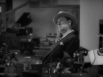 Movie still from “Lady for a Day” (1933), directed by Frank Capra – A man sitting at a table in front of a mirror; Close Up shot, High angle