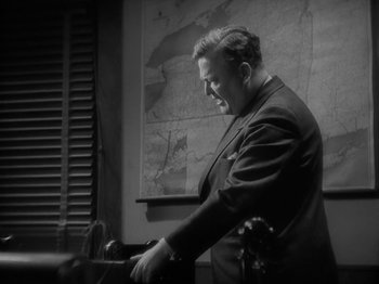 Movie still from “Lady for a Day” (1933), directed by Frank Capra – An old photo of a man in a black suit; Medium shot, High angle