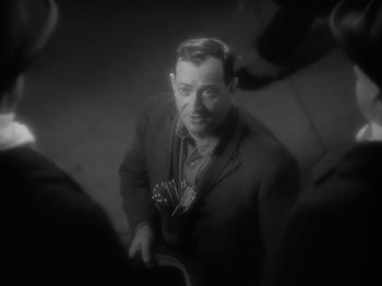 Movie still from “Lady for a Day” (1933), directed by Frank Capra – A black - and - white photo of a man holding a guitar; Close Up shot, High angle