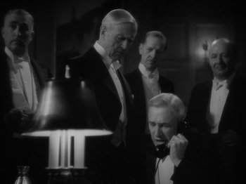 Movie still from “Lady for a Day” (1933), directed by Frank Capra – A group of men standing next to each other in front of a lamp; Medium shot, Low angle