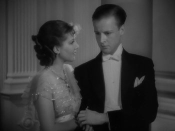 Movie still from “Lady for a Day” (1933), directed by Frank Capra – A man and a woman standing next to each other in formal wear; Close Up shot, High angle