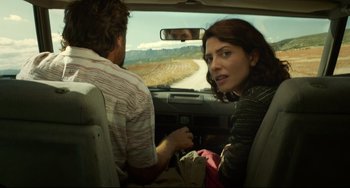 Movie still from “Everybody Knows” (2018), directed by Asghar Farhadi – A man and a woman sitting in the back of a car; Medium shot, Low angle