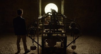 Movie still from “Everybody Knows” (2018), directed by Asghar Farhadi – A man standing in front of an old machine; Wide shot, Low angle