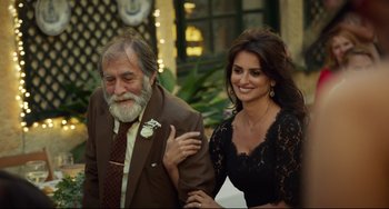 Movie still from “Everybody Knows” (2018), directed by Asghar Farhadi – An older man and a young woman posing for a picture; Medium shot, Over the shoulder angle