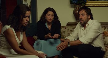 Movie still from “Everybody Knows” (2018), directed by Asghar Farhadi – A group of people sitting around a living room together; Medium shot, Over the shoulder angle